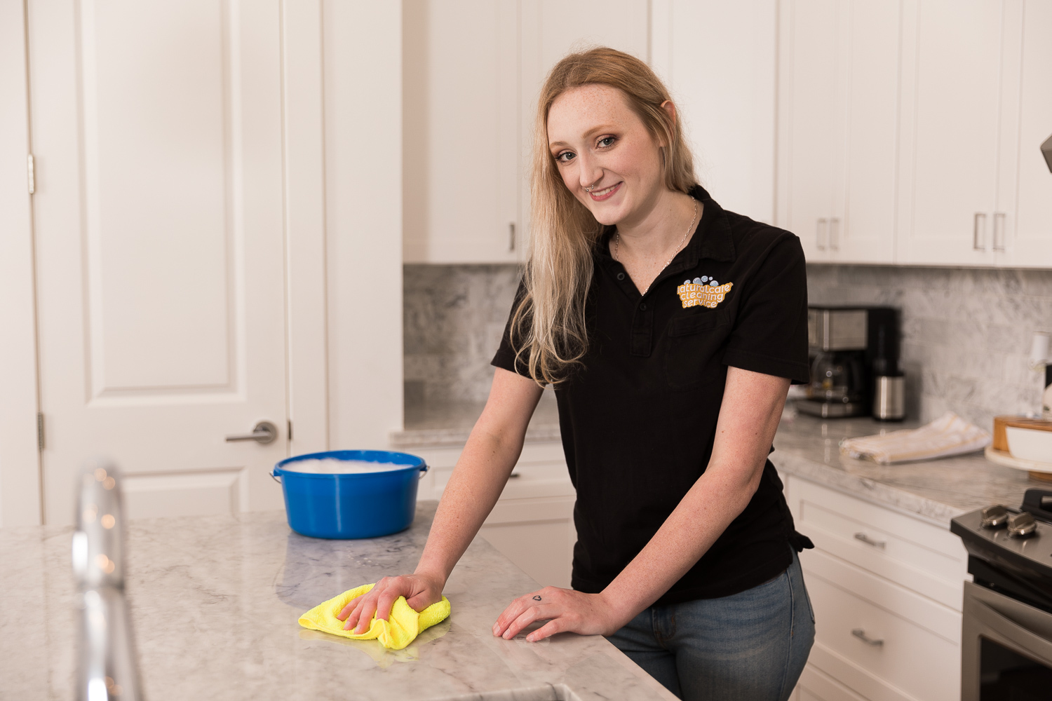 Naturalcare Cleaning Service maid is scrubbing kitchen countertops.