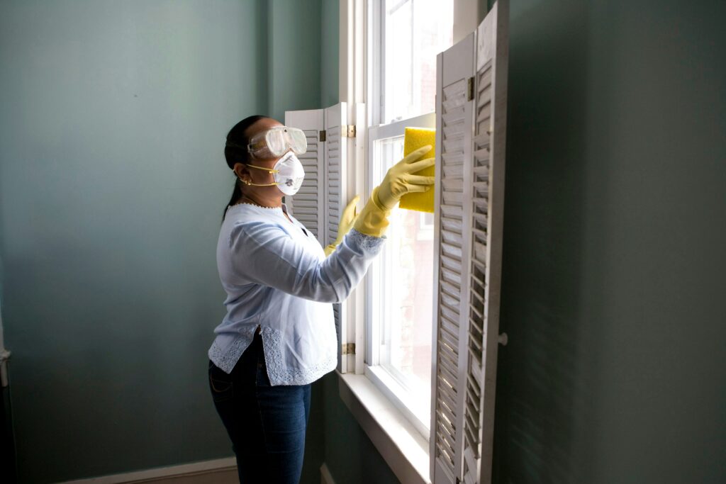 Someone is cleaning a window. The size of your home's windows influence how long does move out cleaning service take.