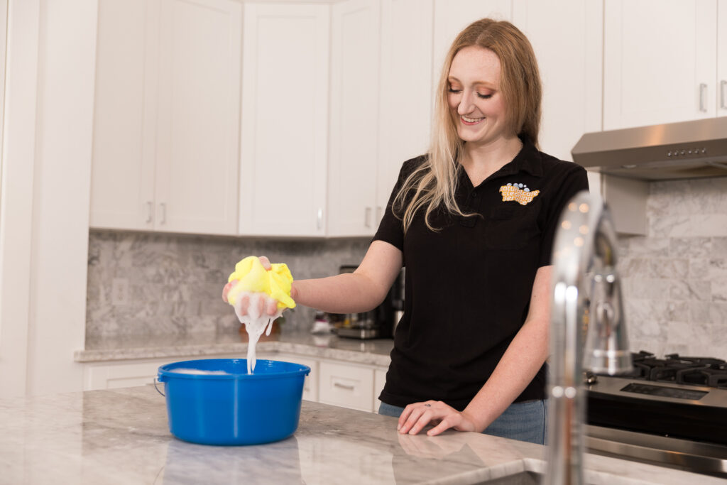A Naturalcare maid is cleaning a kitchen for some much needed AirBnb cleaning service.