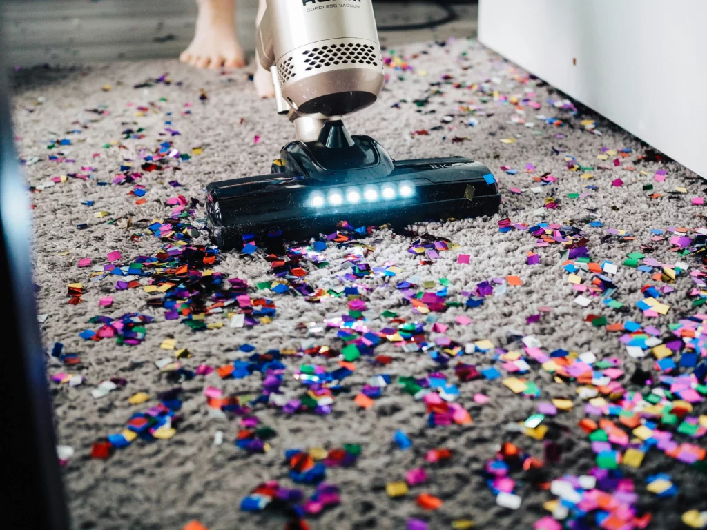 Someone is vacuuming glitter off of a high pile rug. Maid service in Texas helps identify issues to maintain in the house, because staff are paying close attention to details.