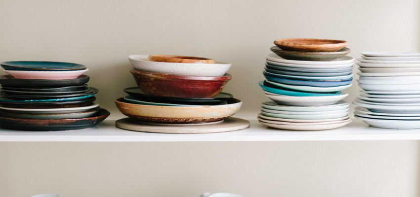Two shelves of clean dishes, assorted styles and sizes. No dirty dishes are in sight.