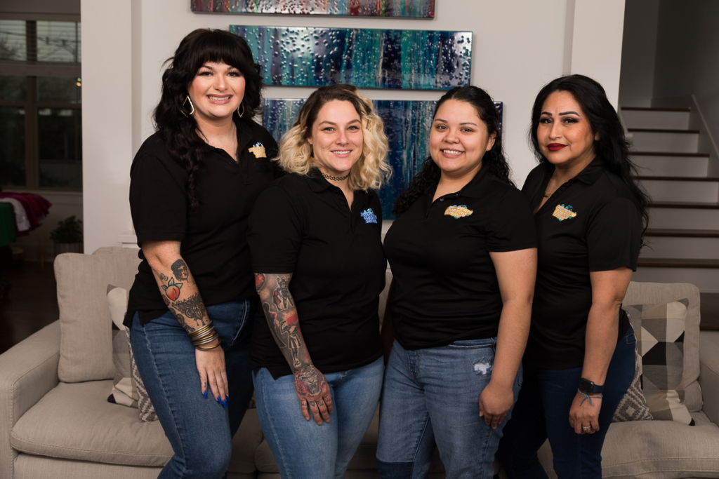 4 professional maids smiling for a photo, all in black polo uniform shirts and blue jeans. They clean every spot in your kitchen, killing bacteria to make your home safer.
